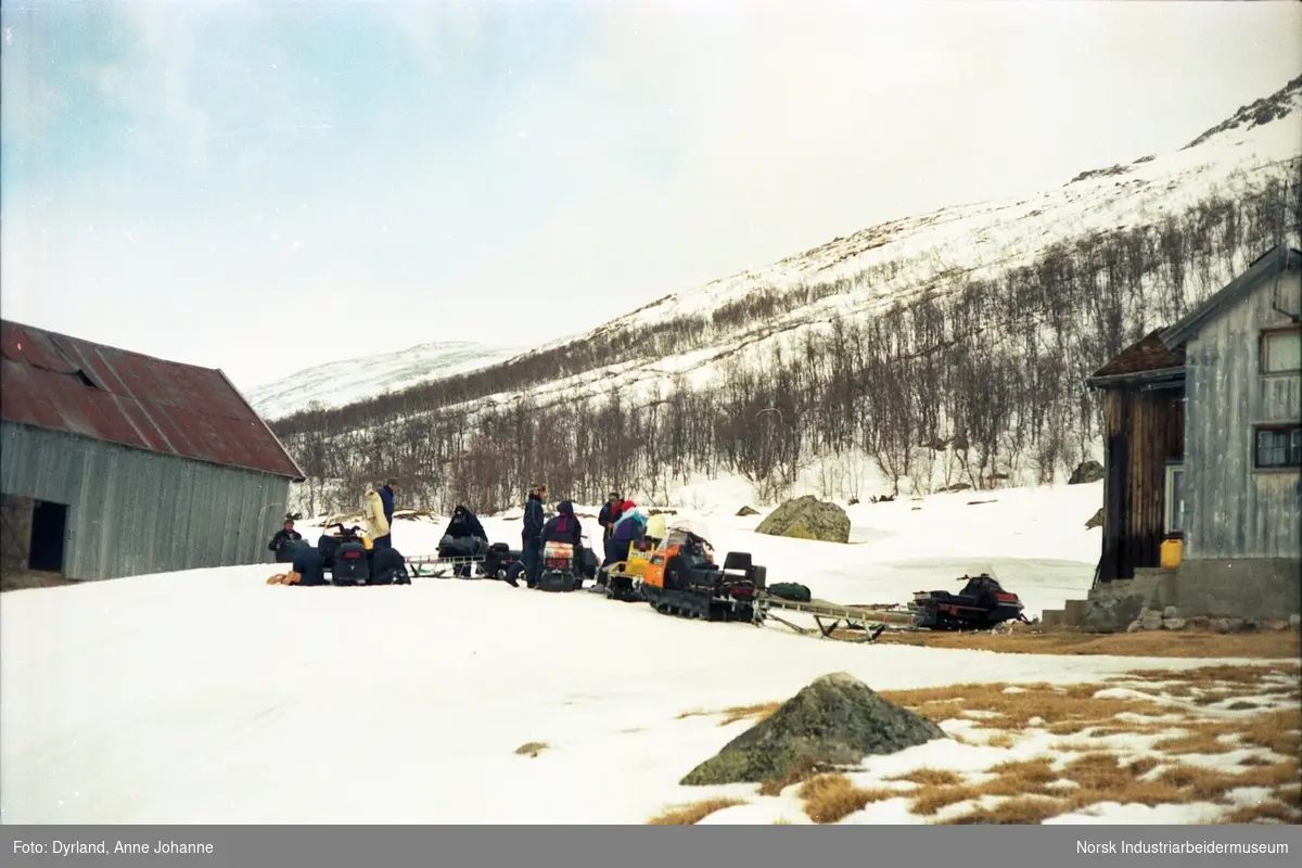 Gruppe med mennesker klar for fjelltur med snøskuter samlet på tunet til gården Skindalen, Møsstrond