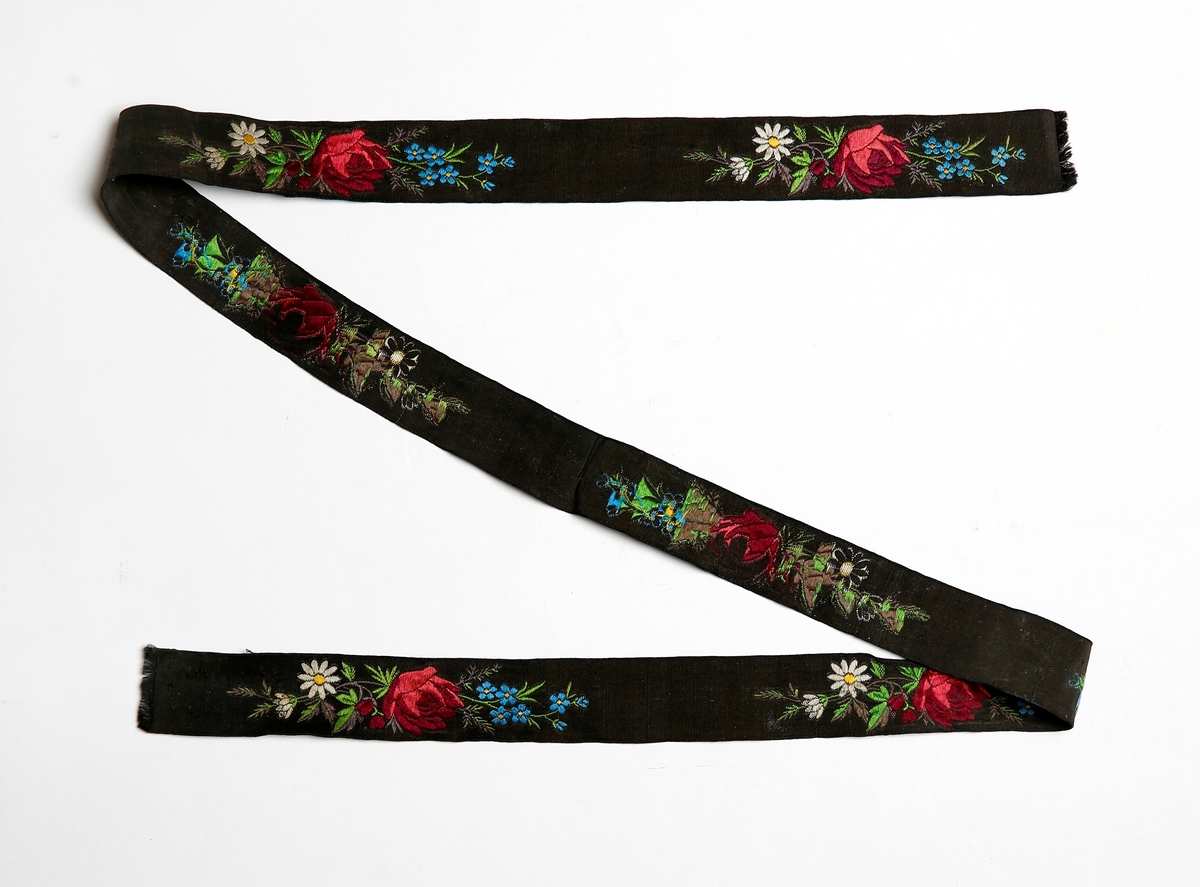 To bånd. 
1: svart nettingbunn med vevd, rødt blomstermønster.
2: svart bånd med brosjert blomstermønster.