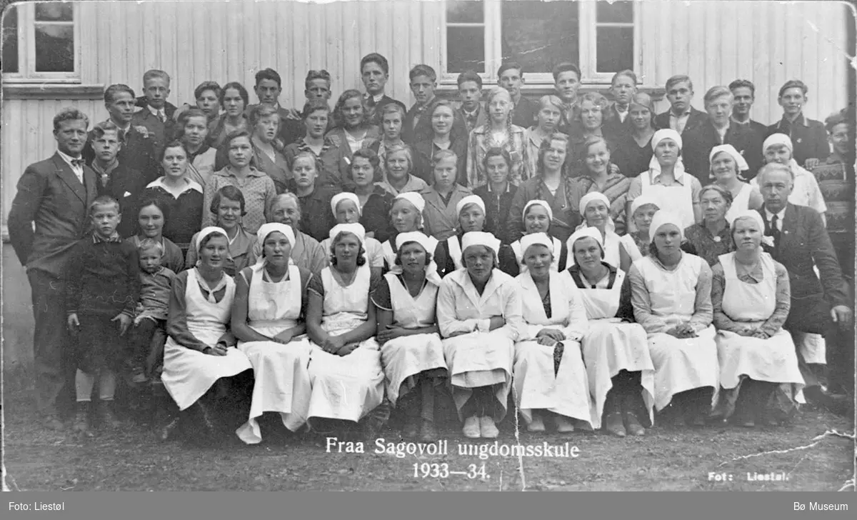 Skuleklasse med litt vaksne ungdomar utanfor skulebygning.
Sagavoll 1933-34