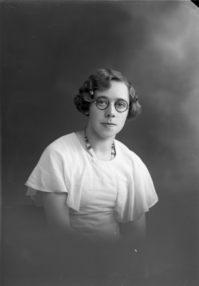 Porträtt av en ung kvinna med glasögon.