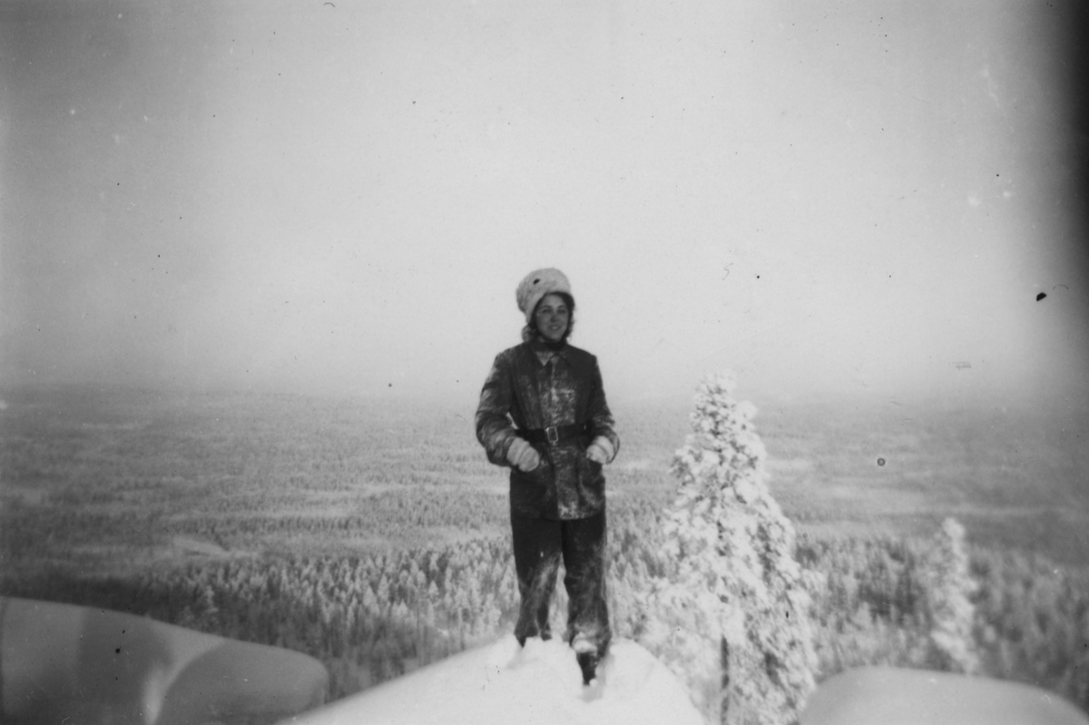 Luftbevakare Inger (efternamn okänt) i uniform på en bergstopp under en skidtur i fjällen, 1942. Inger tillhörde 91:a ls-kompaniet i Tellejåkk, Kåbdalis under beredskapsåren.