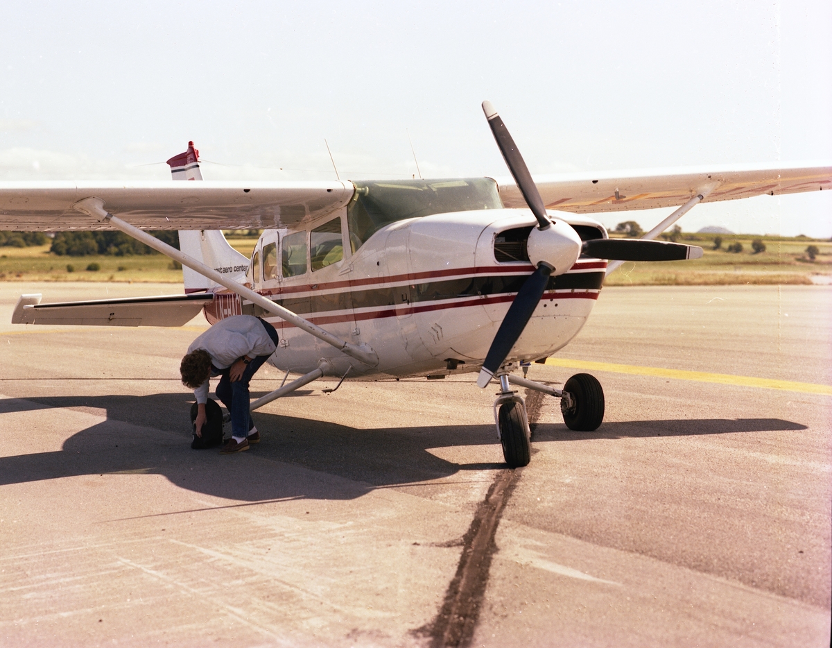 To bilder av et fly med påskriften "LN-HAC" med punktert dekk, og fire flyfoto av et småfly med påskriften "LN-FAM" i lufta, alle fra "Coast Aero Center".