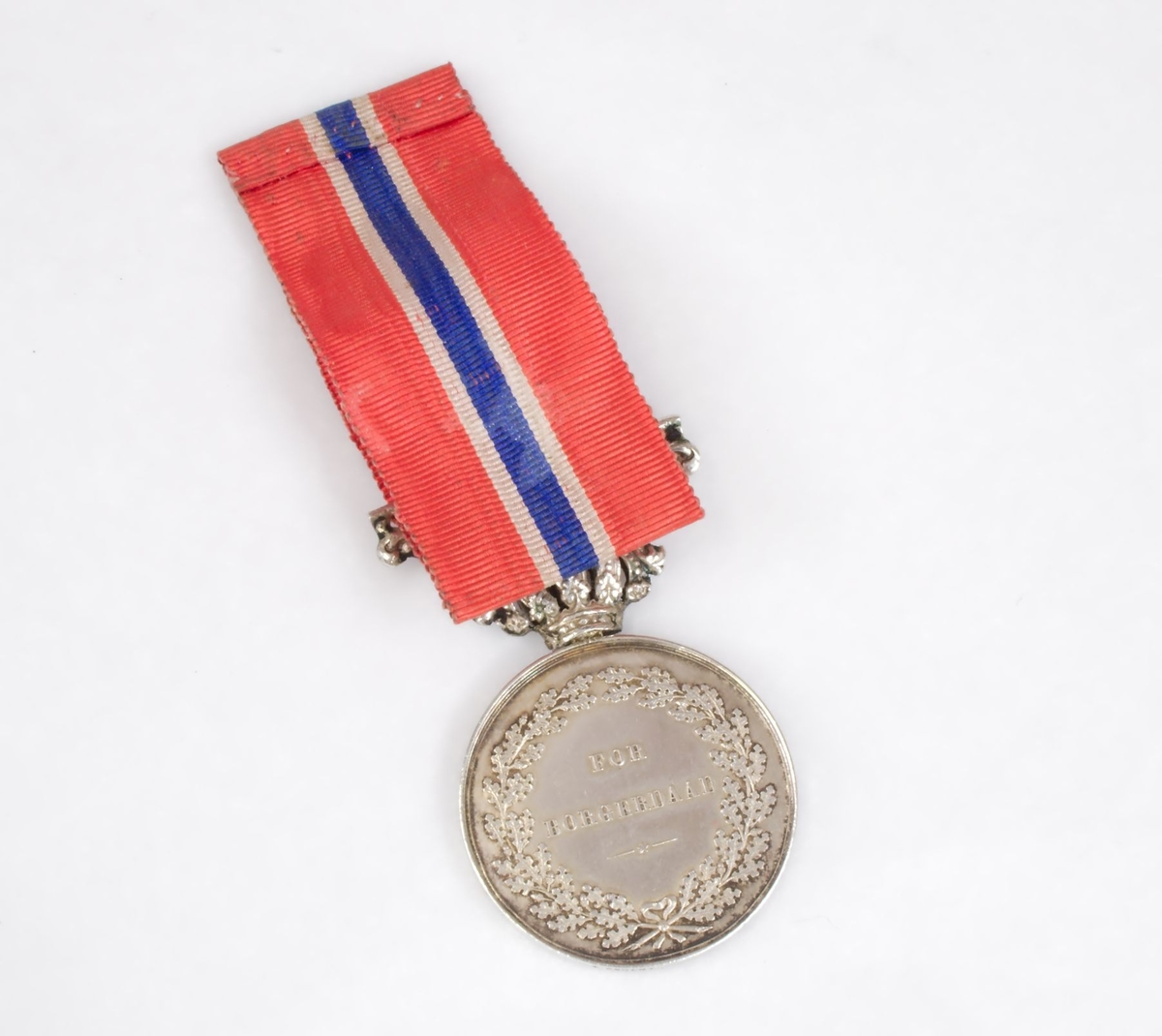 Sølvmedalje med bånd i de norske nasjonalfargene. Den ene siden bærer kong Carl Johans portrett, og den andre siden har ordene "For borgerdåd" omkranset av eikekrans. Hempen har kronedekor. Medaljen oppbevares i originalt etui.