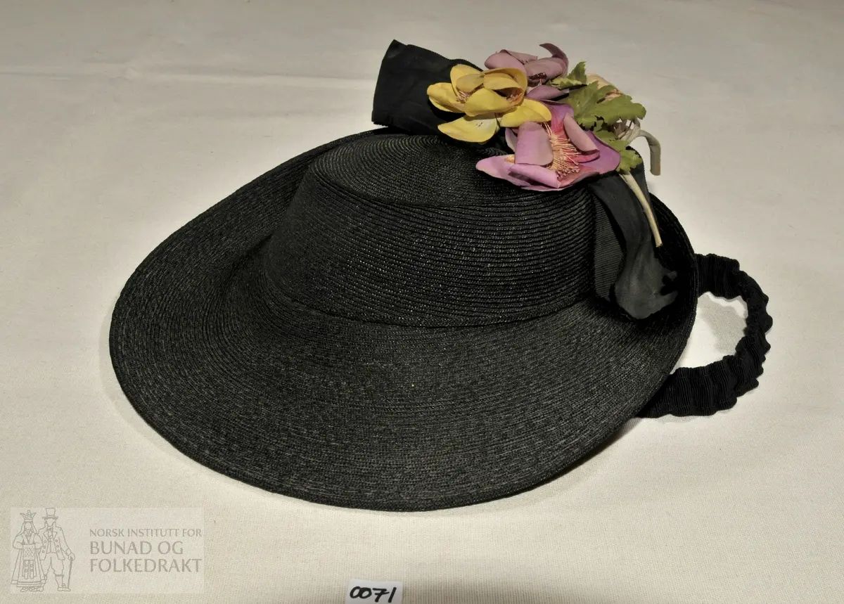 Hatt med stoffblomstrer og 2 stk svarte band i ulike ripskvalitetar. Påsydde hatteband inni, og strikkband av ripsband til festing under haka.