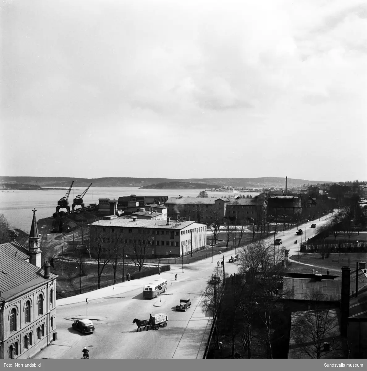 Vyer mot öster utmed Landsvägsallén fotograferade från bygget av Dagbladets fastighet vid Köpmangatan 1. Hästekipage, bilar och bussar samsas på gatorna. KPS, Coronabageriet och den stora gasklockan i mitten av bilderna.
