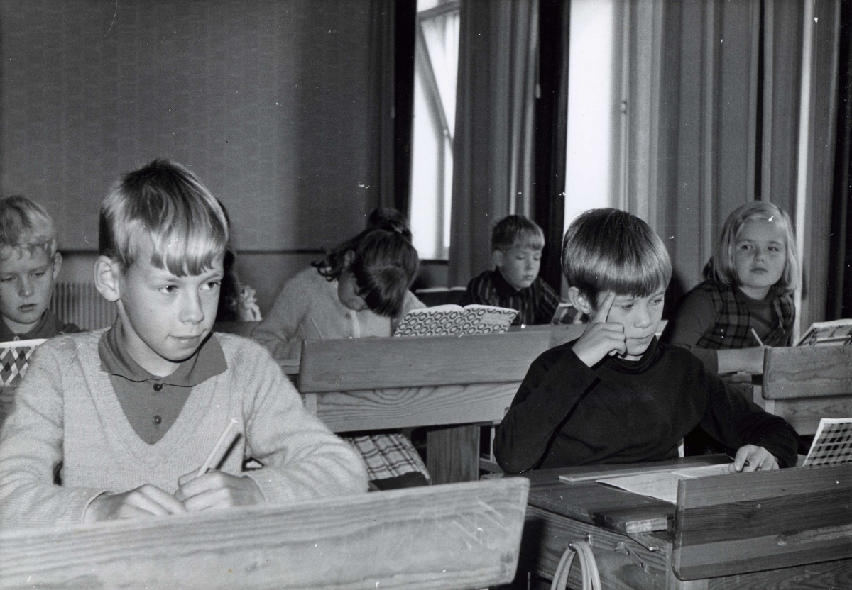 Elever födda 1955 sittandes vid sina skolbänkar i klassrummet, Kålleredsskolan 1966/67. Från vänster: (i bakgrunden) Börje Glamheden, Ove Englund och (nerböjd) Ulla Johansson. Längst till höger sitter Elisabeth Söderkvist.