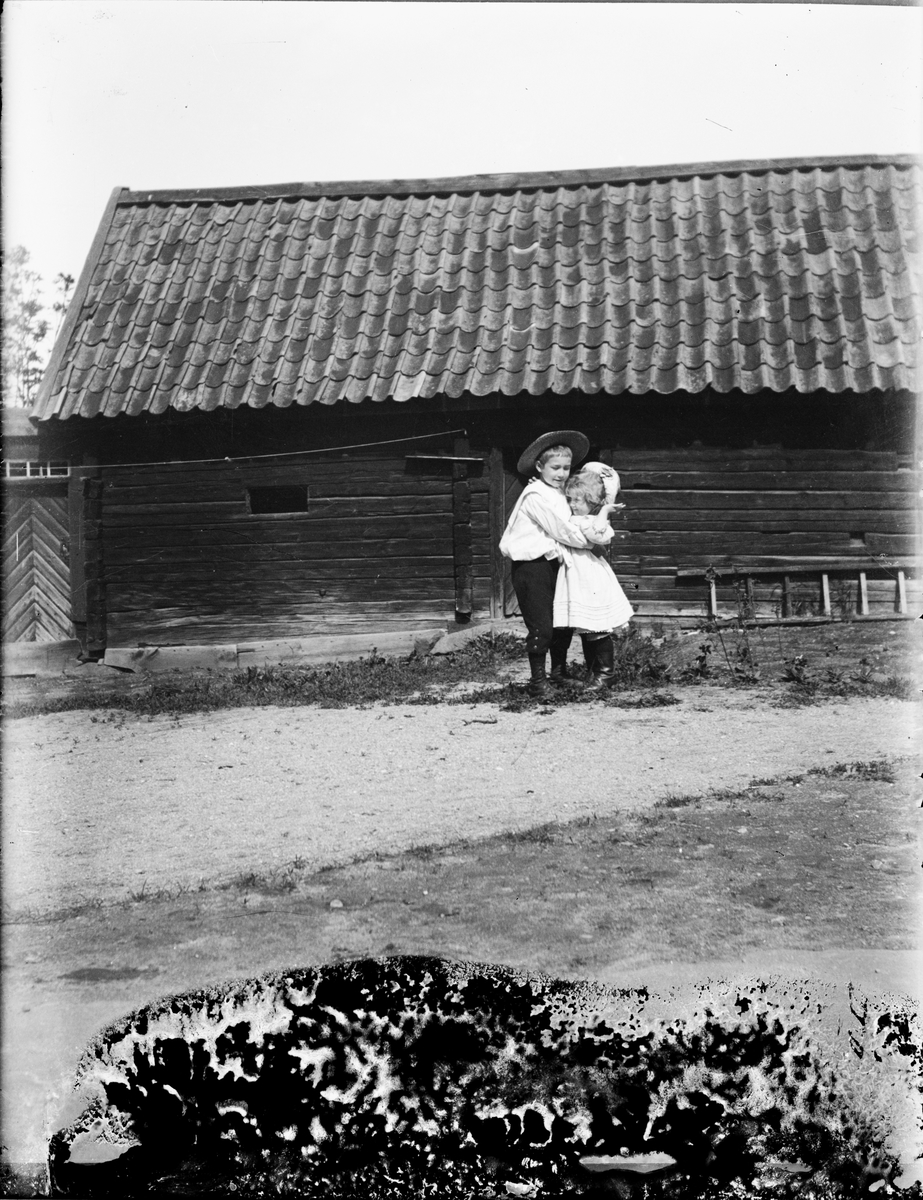 Josef och Sara Edhlund står på gårdplanen och kramas, Guldskäret, Östhammar, Uppland