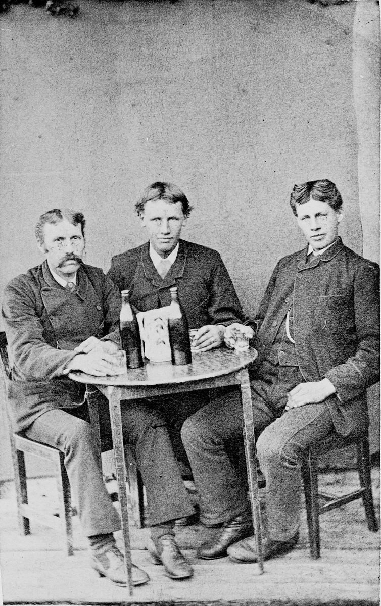 Herrelag med flasker på bordet. Atelierbilde fra Kristiania 1890.