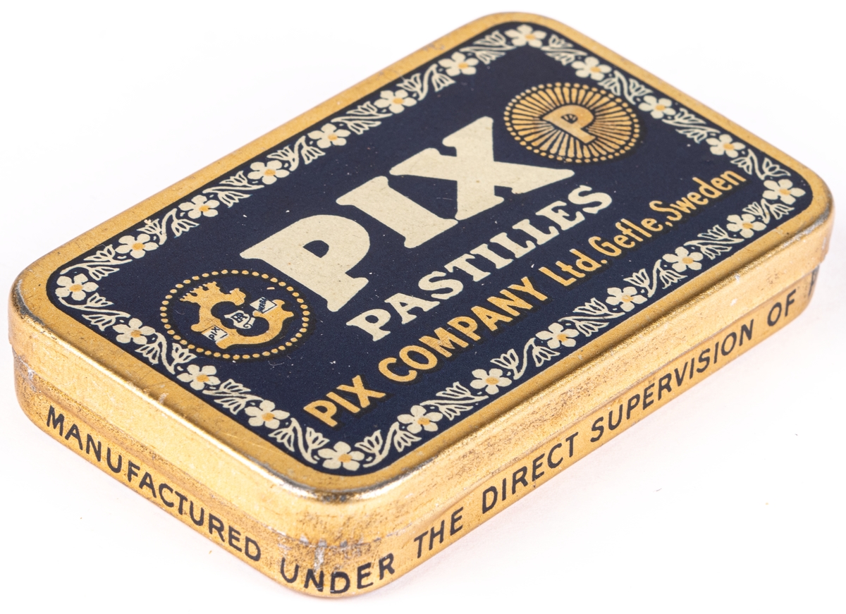 Tablettask i plåt, guldfärgad och blå botten med vit och guldfärgad text:" PIX PASTILLES PIX COMPANY LTD. GEFLE. SWEDEN".