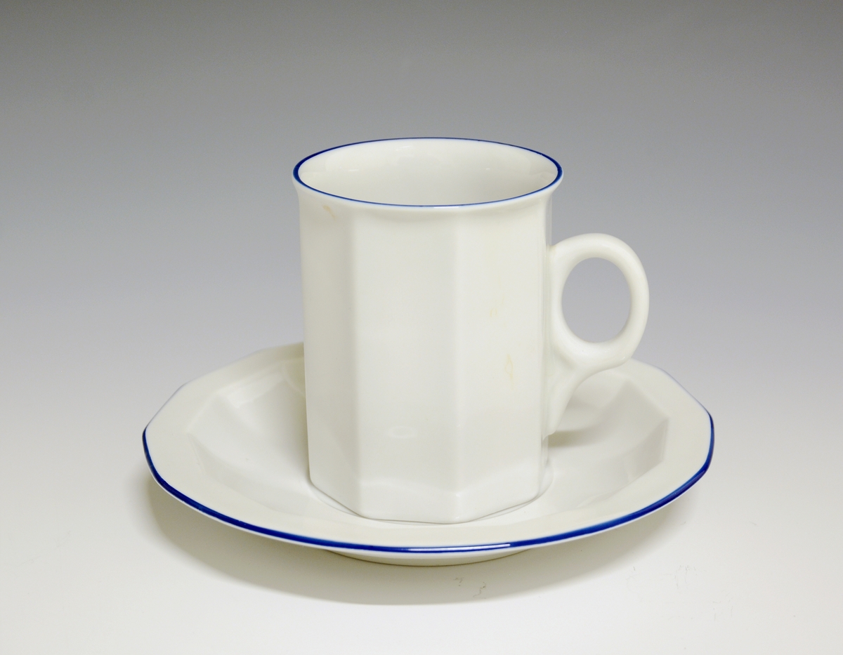 Mangekantet kopp i porselen med blå kantstrek som eneste dekor. Hvit glasur.
Modell: Octavia, tegnet av Grete Rønning i 1977.
Dekor: Blå strek