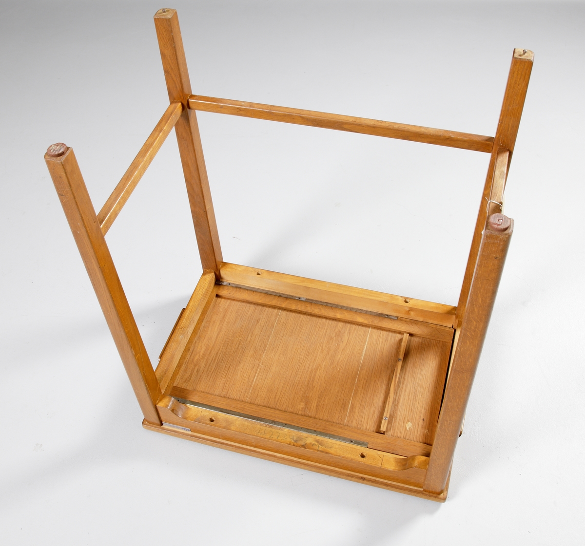 Ett rektangulärt, enkelt skrivmaskinsbord av fernissad ek och furu, på fyra ben. Utdragbara avlastningsskivor på var kortsida.