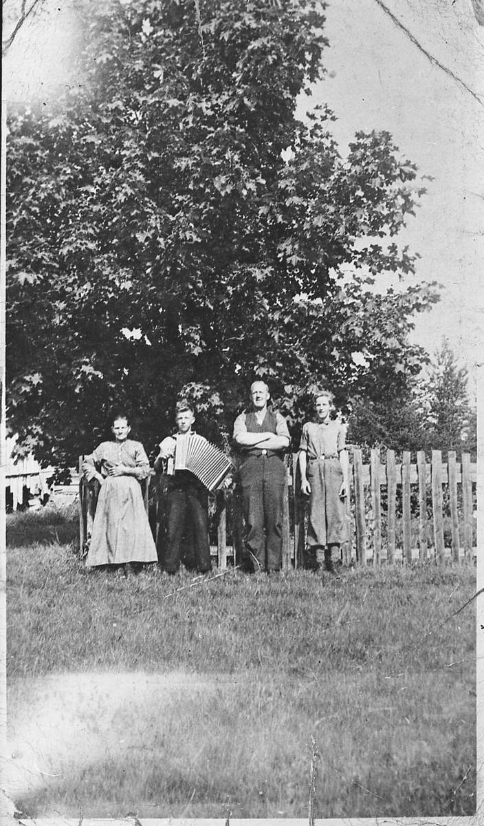 Gruppebilde foran den store lønnen på Emmerud, 1938.
