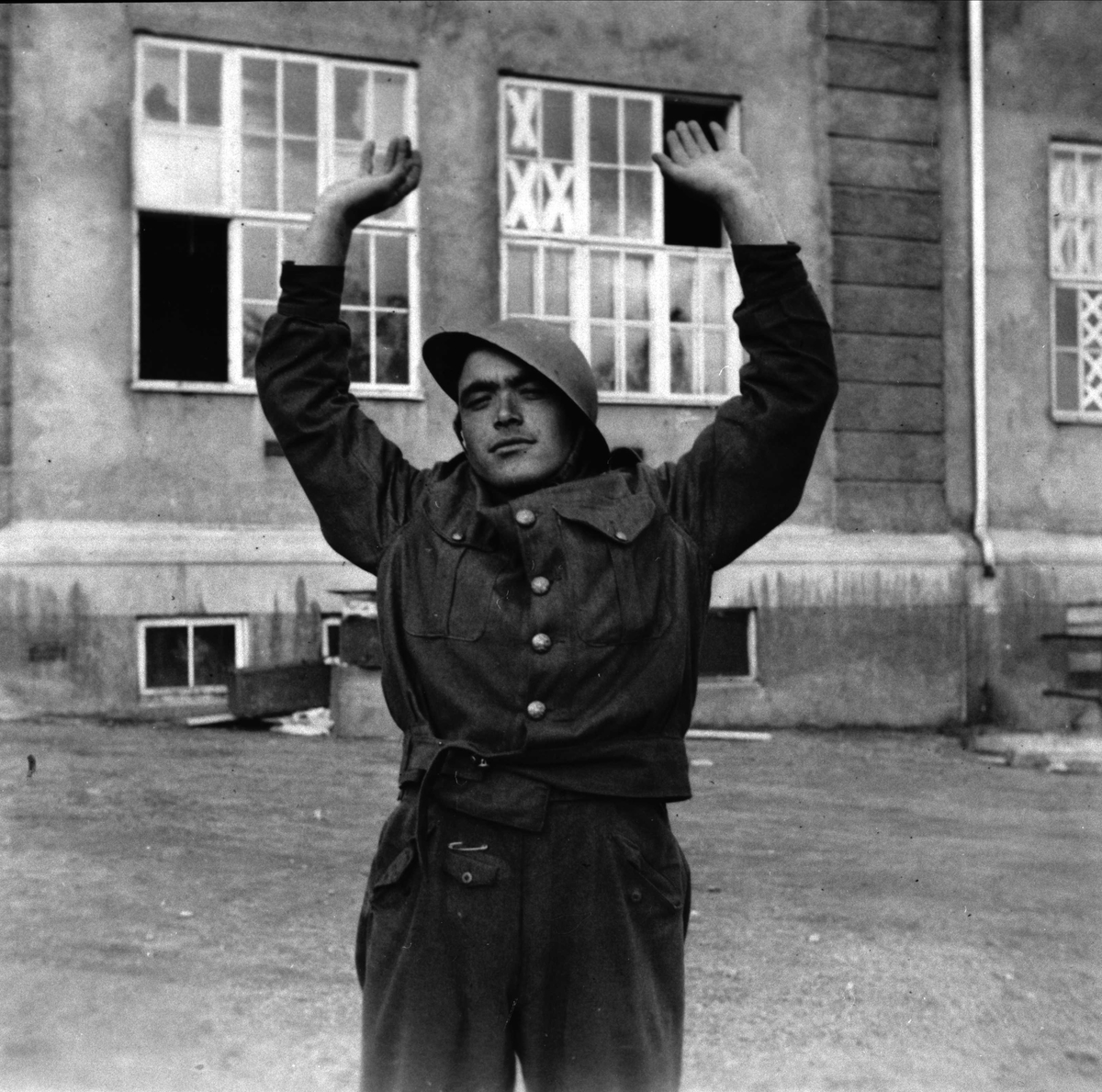 Soldat med hendene i været, fotografert foran byskolen i Harstad.