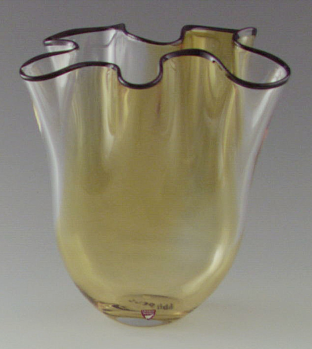 Vas, Höstklockan,  formgiven av Gunnar Cyrén för Orrefors. Svagt gulfärgad med rand upptill längst mynningen. Veckad form.