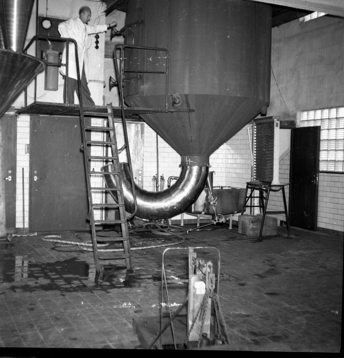 Interiör från livsmedelsindustrin AB Sprayprodukter i Gränna. Fabrikör Jan Campbell står högt upp vid en pulvermaskin.