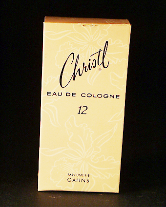Förpackning av papp med tryckt blommönster i rosa och vitt och svart text: "Christl EAU DE COLOGNE 12 Parfumerie Gahns, Förtjusande...med en doft som talar omkultur och förfining...det är Christl från Gahns."