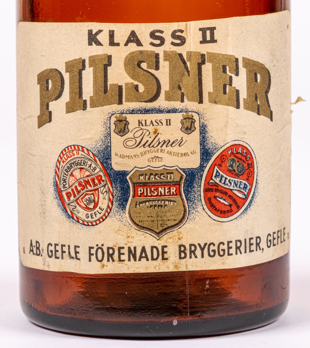 Flaska. Brunt glas. Patentkork, metall. Etikett: "PILSNER KLASS II GEFLE" m.m.
A.B. Gefle förenade bryggerier, Gefle.