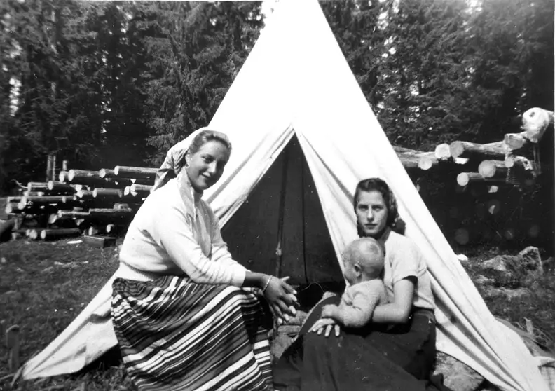 To velstelte reisende kvinner med et barn på ei slette.