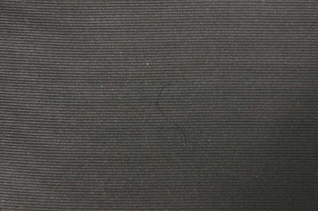 Stoff av svart silke rullet opp på trestokk. Nytt stoff m/jare i sidene. Tre ulike stoffer er rullet opp på stokken.