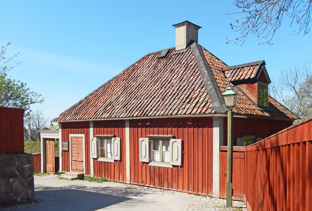 Sparbanken i stadskvarteren på Skansen är en timrad envånig byggnad klädd med stående locklistpanel. Fasaden är målad med röd slamfärg, snickerier i grå linoljefärg. Taket är högt, valmat och toppigt, klätt med enkupigt lertegel. 

Byggnaden är troligen uppförd omkring 1700. Huset flyttades från Bondegatan 54 på Södermalm i Stockholm och återuppfördes på Skansen på sin plats i stadskvarteren 1946.