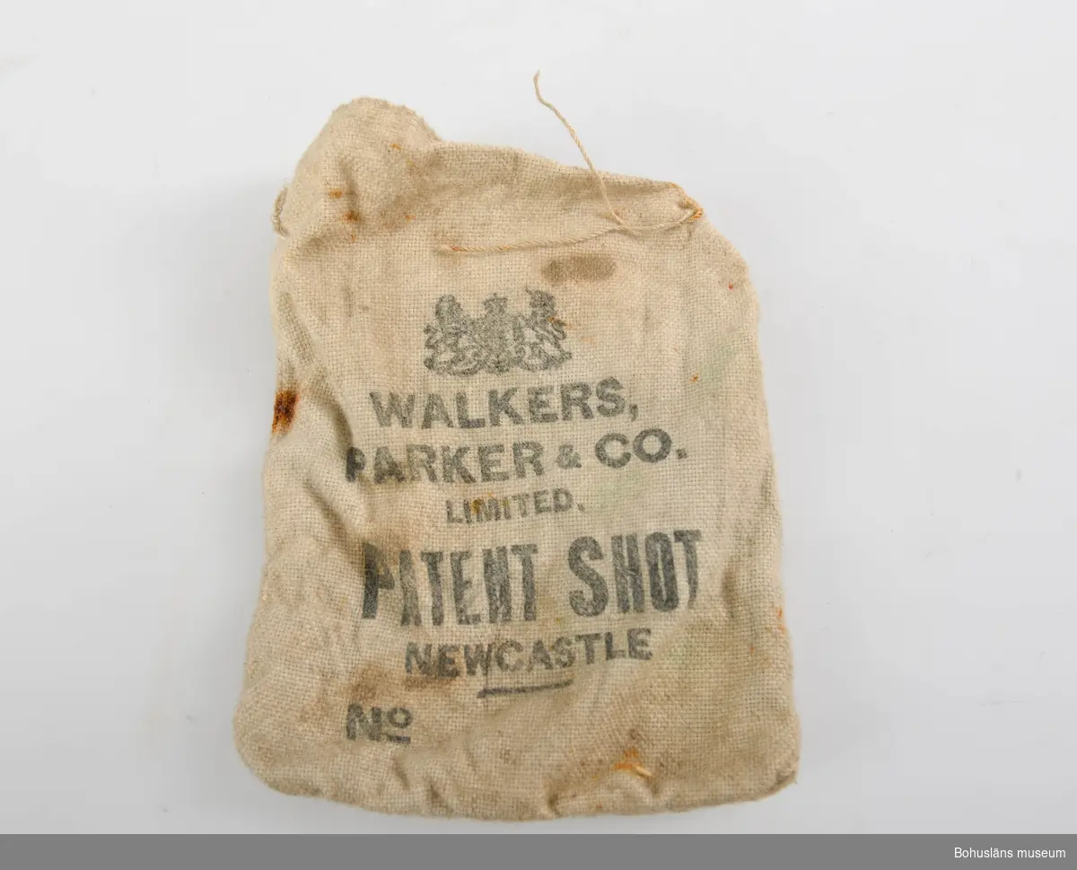 Tom kulpåse av bomull eller linne med tryckt text i svart: 
WALKERS, PARKER & CO. LIMITED PATENT SHOT NEWCASTLE