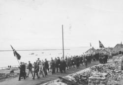 7.mai 1945. Folketog i Havnegata i Vadsø. Vi ser rester ette