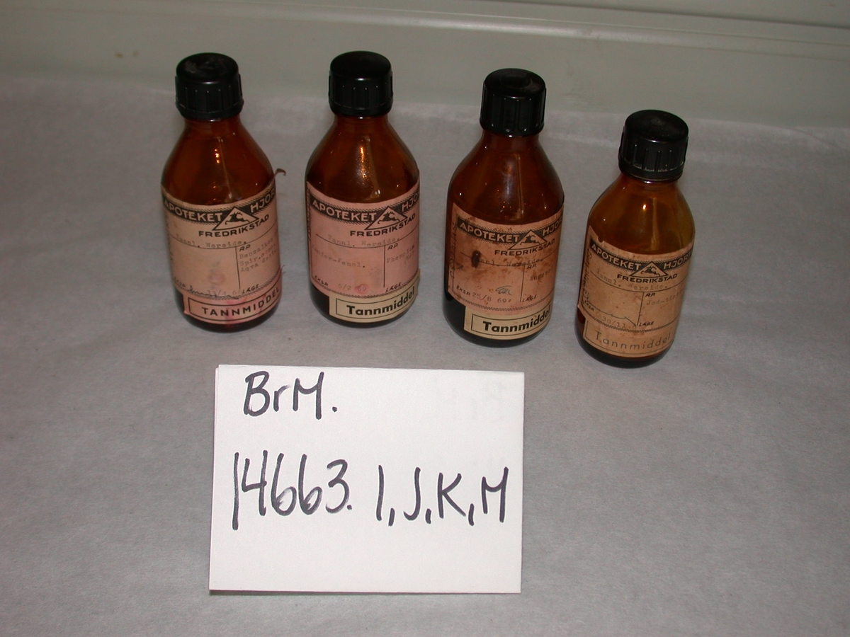 A-M: 13 stk. flasker og beholdere i glass inneholdende tannmiddel. Tannmiddel er et standard samlebegrep fra apoteket. 

A-I: inneholder innleggsmateriale til rotfyllinger
J-M: inneholder nellikolje (Eugenol). Det er dette som lager den velkjente "tannlegelukten". Denne brukes til blanding av midlertidig sement sammen med sinkoksyd. 
K = desinfeksjonsmiddel
L: sinkklorid til blanding av sement
M: til desinfeksjon (jod).