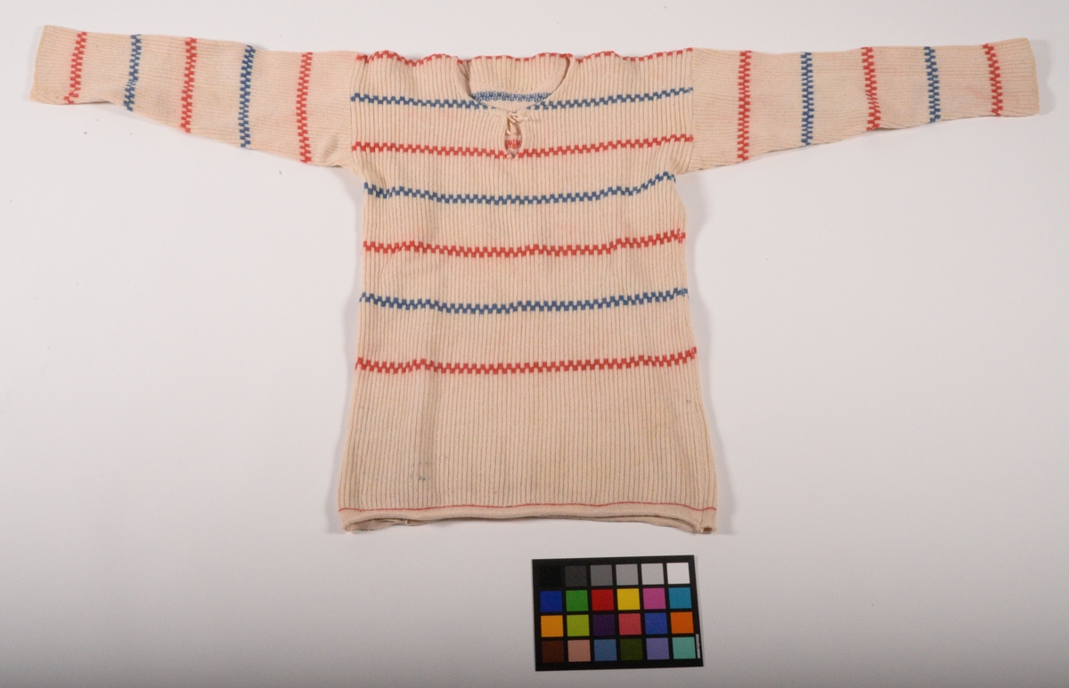 Stickad tröja med ränder i blått och rött. Så kallad "Pippitröja". Tröjan har tillhört Oscar Sampson som tillsammans med sonen Hilding drev ett skrädderi i bostaden i Långared.