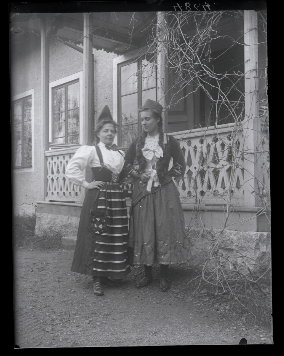 Två kvinnor i folkdräkt, vid prästgården, Lillhärad.