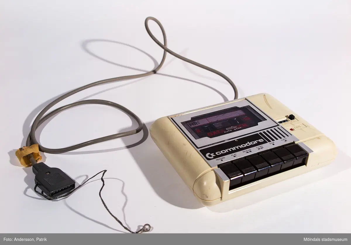 Kassettenhet, C2N CASSETTE.
Beigefärgat plasthölje med logotypen Commodore. Svarta knappar och räknare.