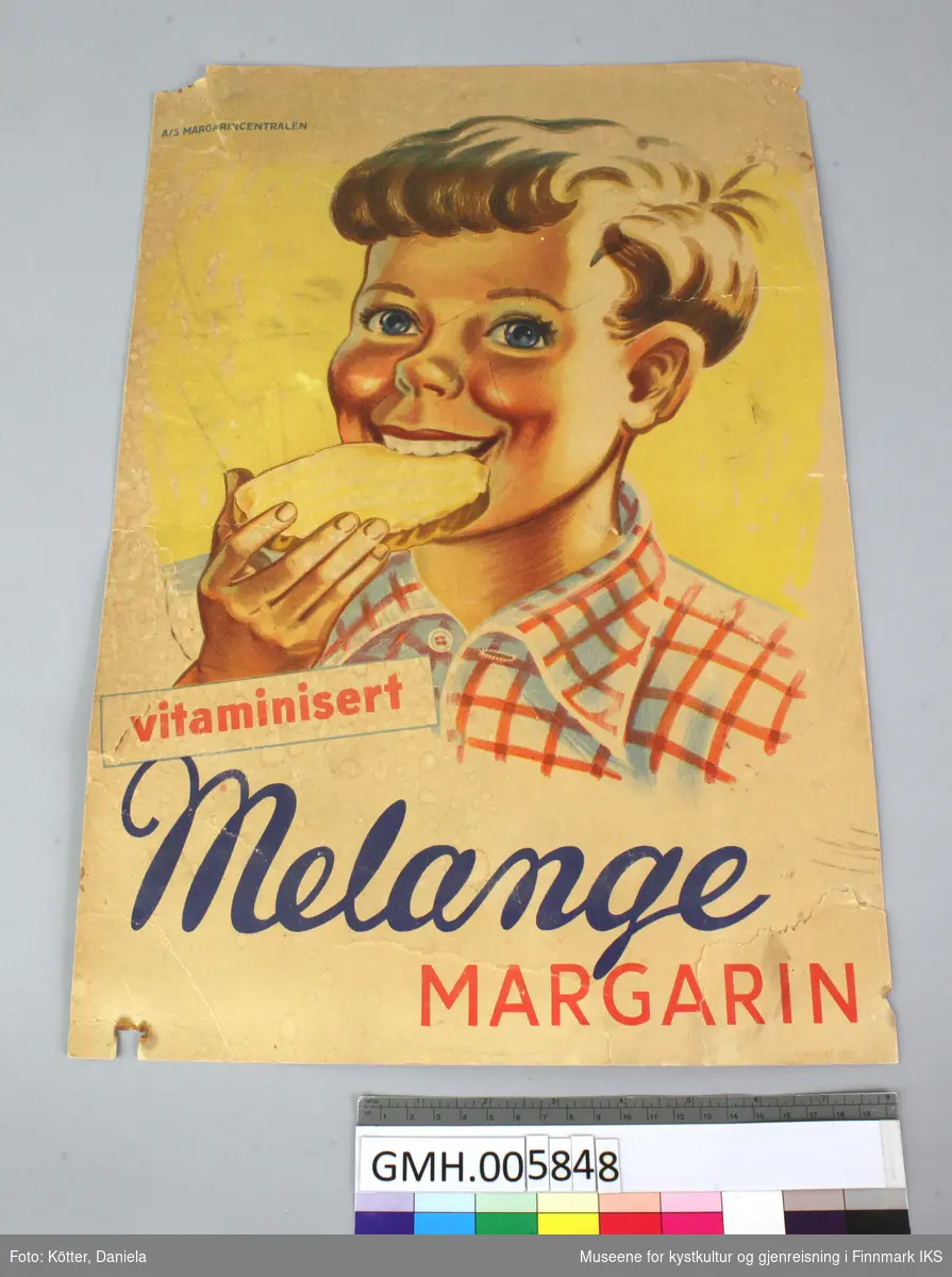 En gutt i hvitt og rødt rutet skjorte spiser en brødskive med margarin.