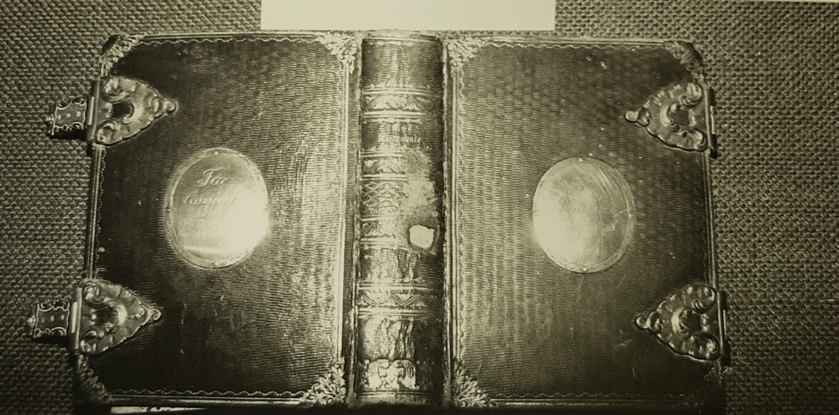 Rektangulær bok, skinninnbundet med sølvbeslag.. Boken lukkes med to sølvspenner.