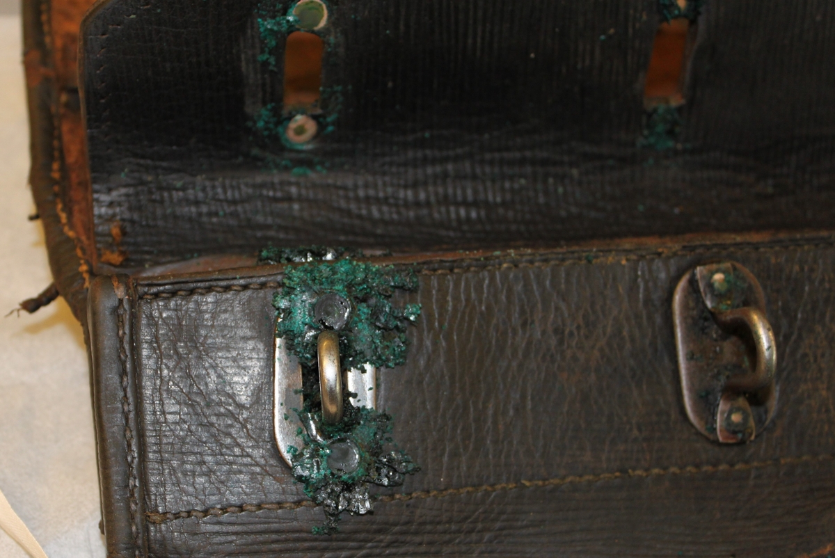 Postväska, s k lösväska av svartbrunt läder och låsanordning med hänglås under locket (metallöglor genom vilka en järnten fördes och låstes). Väskan försedd med en ställbar bärrem. Med en klaff som lock över öppningen. Denna spändes fast med en läderrem och spänne. Ovan remmens fäste på klaffen sitter en mässingskylt med text "PORSABYGGET".