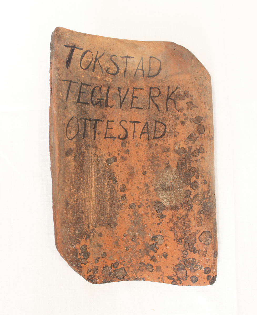 Taksteinen er fra Tokstad teglverk. Teglverket var i drift store deler av 1800-tallet. 

Fra samlingen etter Ole Gjestvang. 