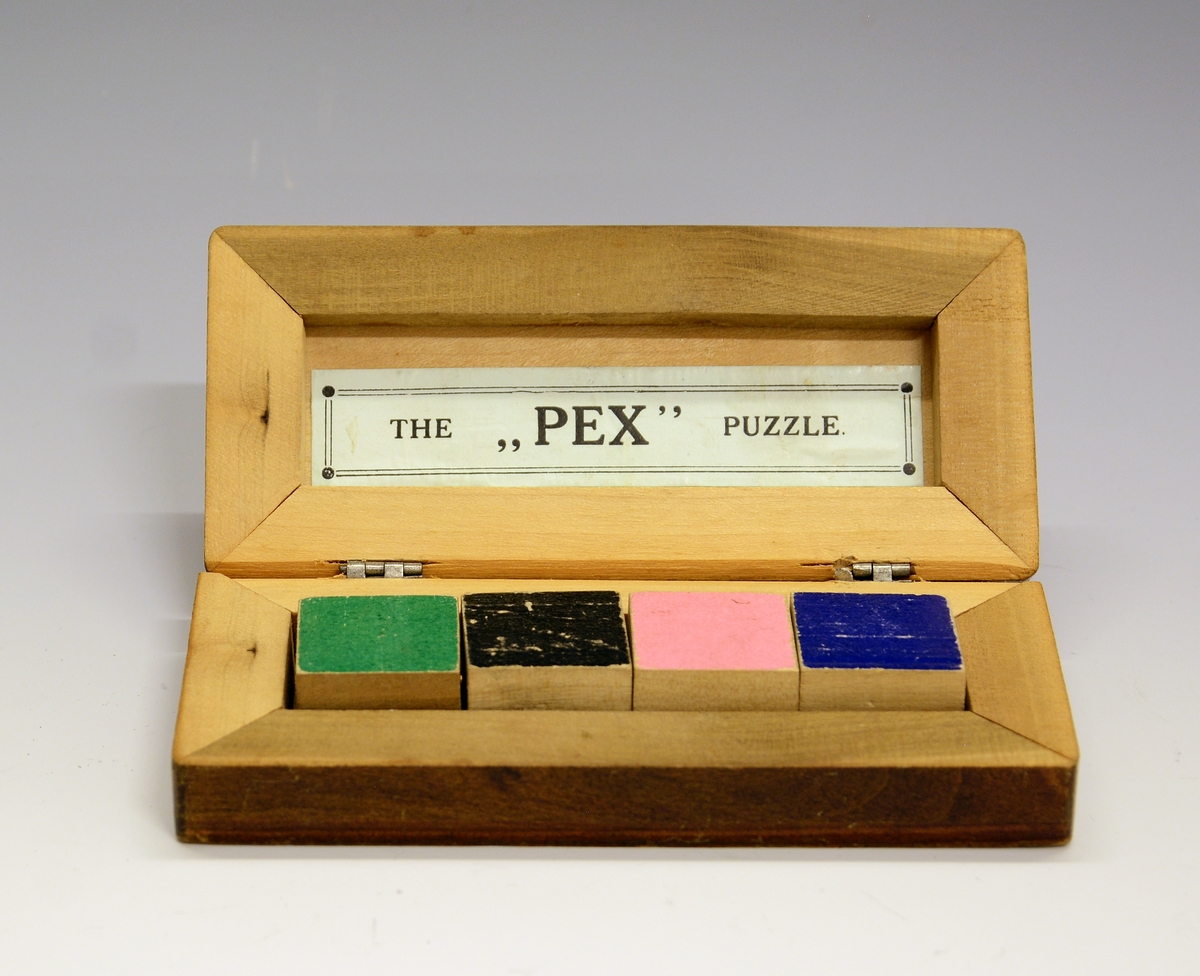 Spill i treeske, The "Pex" Puzzle. Spillet består av fire treklosser med farge på to sider.