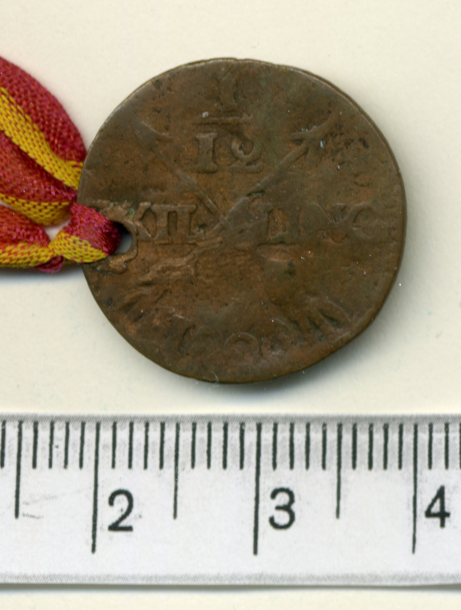6. 1/12 skilling 1808 Gustaf IV Adolf.

Myntet har ett band knutet genom ett hål.