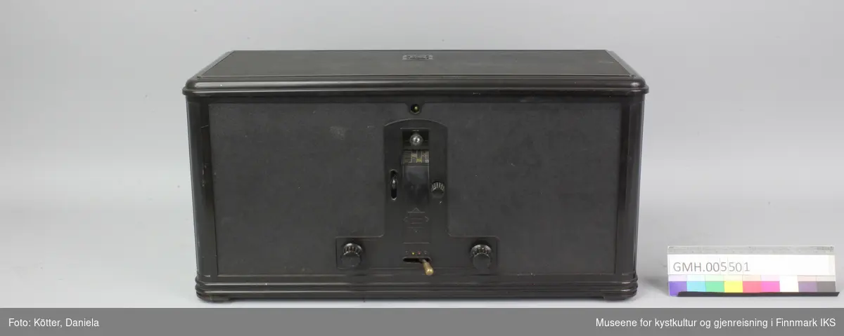 Radioens korpus og den knapper er laget av svart kunststoff, mest sannsynlig Bakelitt. Kantene er avrundede og profilerte. I fronten er det en liten rund lyspære. Med en dreieknapp kan skalaen inn i korpuset dreies på ønsket frekvens.