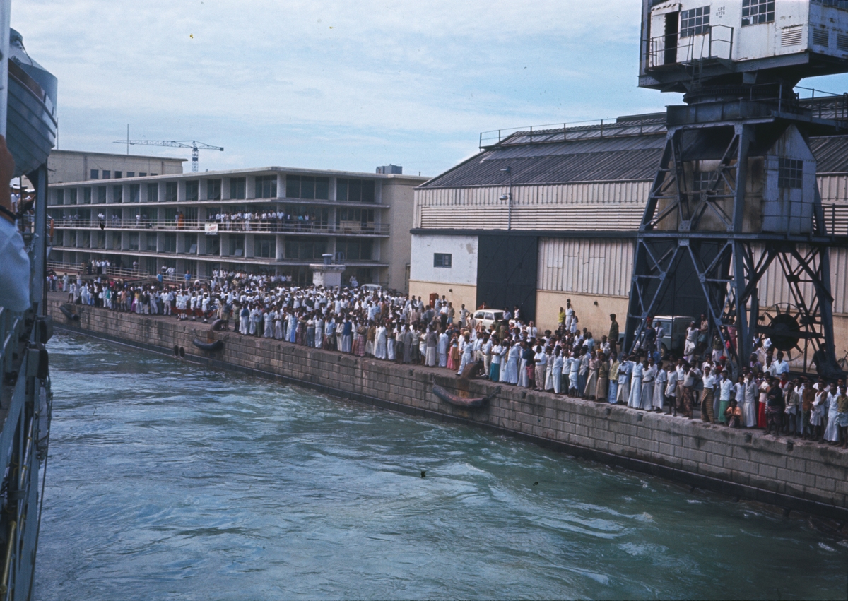 Bilden visar en folkmängd i hamnen av Colombo som inväntar Älvsnabben som håller på att lägga till vid kajen.