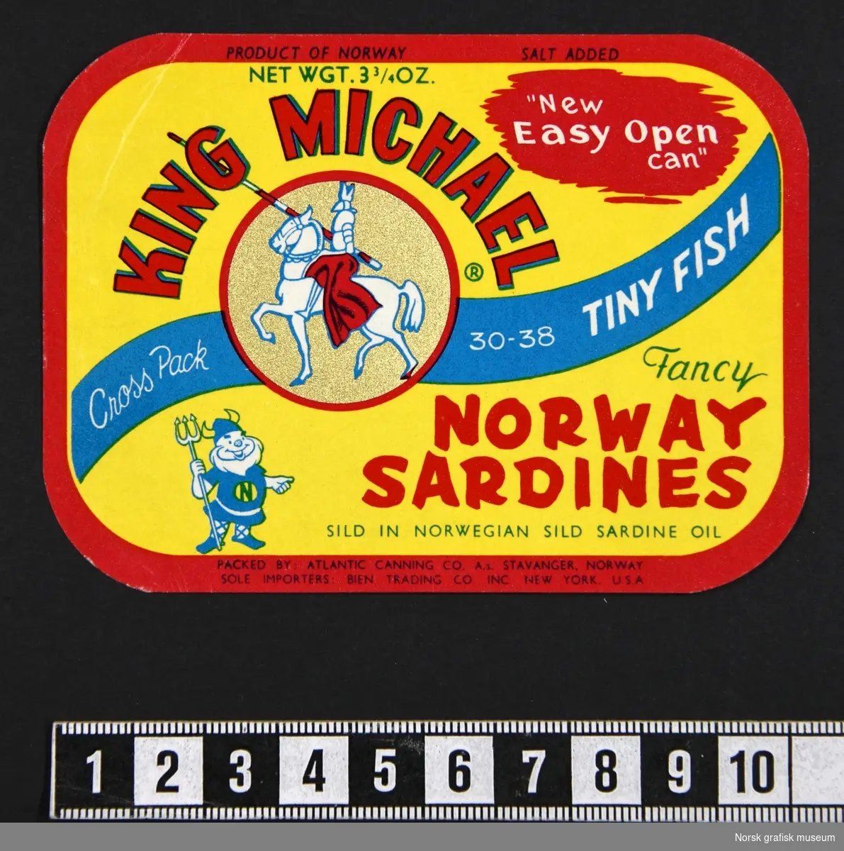 En bunke med gule etiketter med rød ramme. En blå bølget linje går diagolnalt over, med varemerkets logo (en rytter med lanse) i en sirkulær ramme. 

"Fancy Norway sardines sild in Norwegian sild sardine oil"