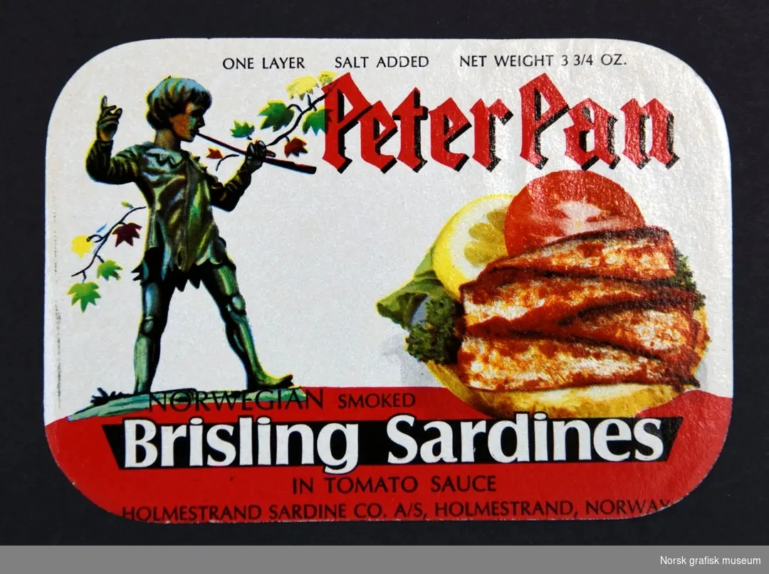 Etikett med hvit og rød bakgrunn. Ved siden av en gutt som holder en pinne (trolig Peter Pan) er en fremstilling av sardiner dandert med sitron og tomat. 

"Norwegian smoked brisling sardines in tomato sauce"