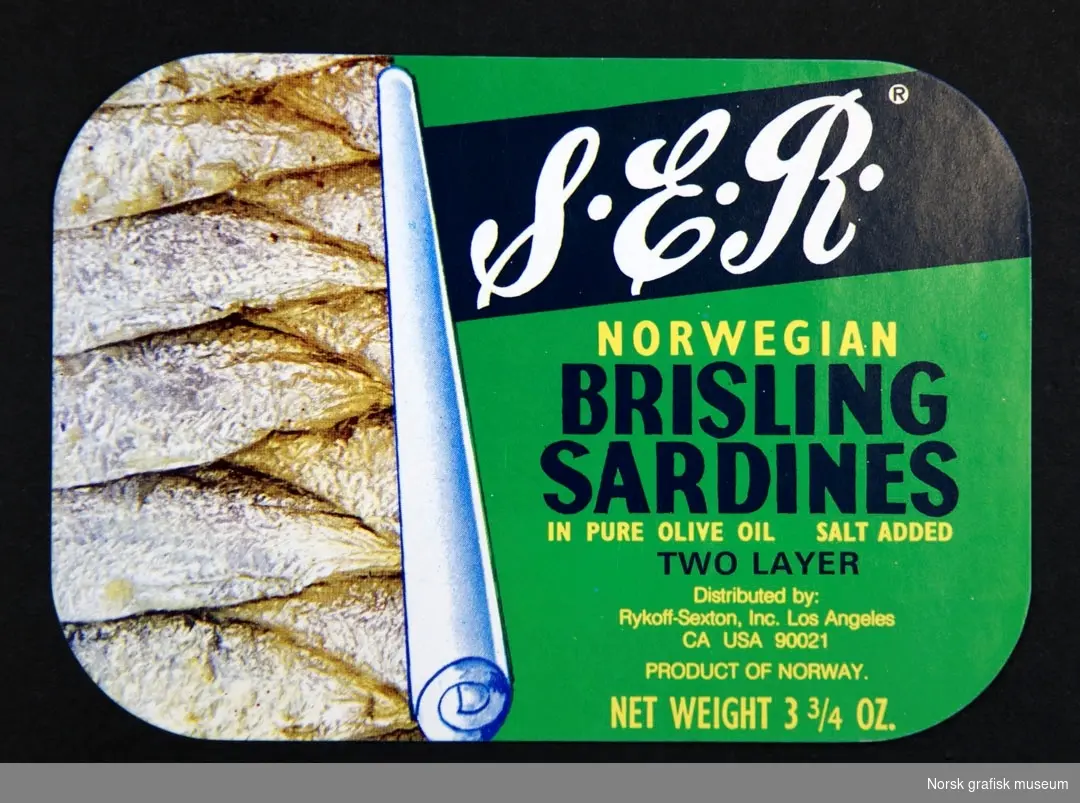 Grønn etikett med bilde av hermetikkboksens innhold (sardiner) på venstre side. 

"Norwegian brisling sardines in pure olive oil"