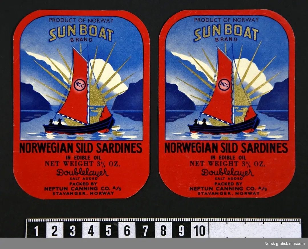 To etiketter i gødt og blått. Bilde av en seilbåt med en strålende sol i gull i bakgrunnen. 

"Norwegian sild sardines in edible oil"