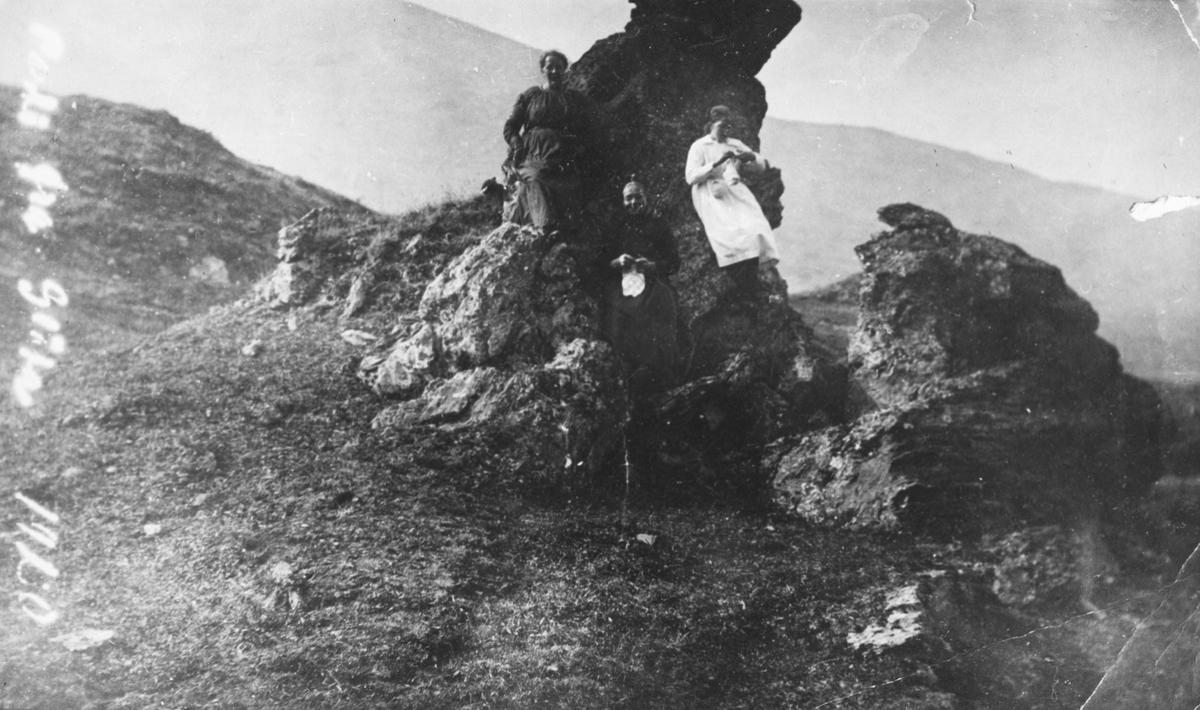 Tre kvinner ved ein snodig stein ved Gløtsetra