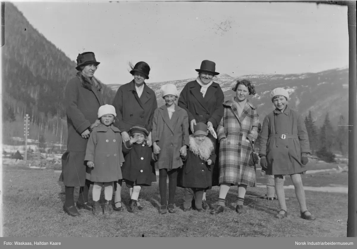 Kvinner og barn stående oppstilt på slette, sannsynligvis på Bjørkhaug (der butikken Kiwi er i dag).