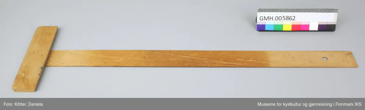 Linjalen er den mellomste av tre linjaler og har en cm-skala til 72. Den er gulbrun og har et fast tverrstykke i enden som som holder linjalen i rett vinkel i forhold til tegnebrettets sidekant.