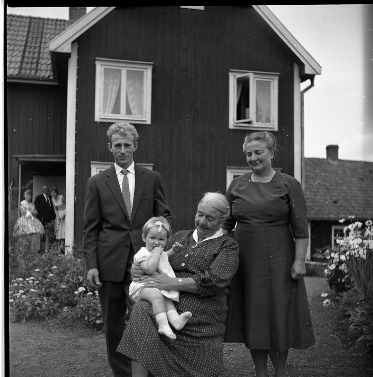 Fyra generationer samlade på gårdsplan till en fastighet i Kaxtorp. Ester Karlsson sitter med en liten flicka knät. Bakom henne står dottern Britta Granstrand och till vänster hennes barnbarn Sten Egon Granstrand.