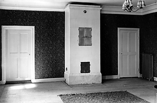 Kakelugn och dörrar i matsalen, i bostad på Hässlö gård i Västerås.