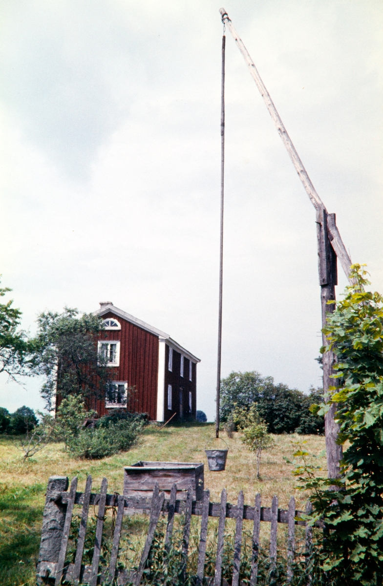 Gård med brunnsanordning av trä. 1958.