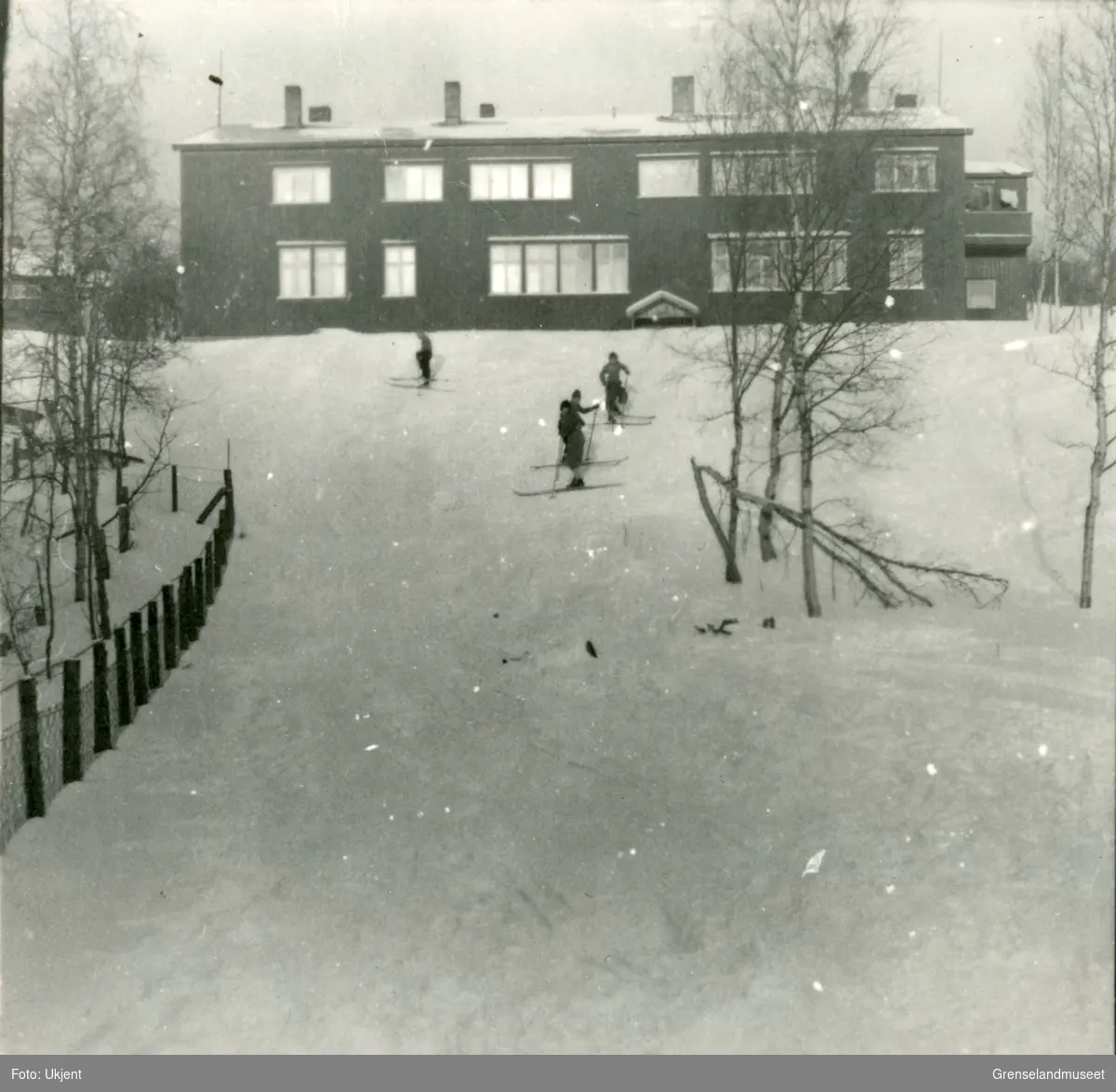 Ropelv skoleinternat. Bygget i 1947. Internatet hadde plass til 25 barn. Den ble benyttet som framhaldsskole fra 1957. Fire barn går på ski i bakken foran skolen.