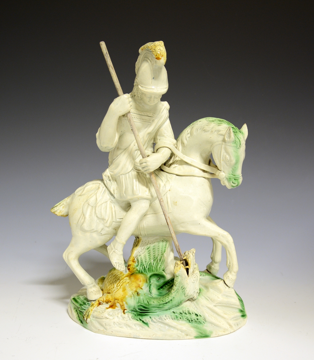 St. Georg til hest dreper dragen. Hvitglasert fajanse med håndmalte detaljer i grønt og gult.